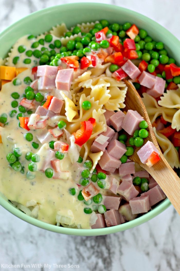 Ham, peas, bell pepper, cheese, and pasta mixed in dressing.