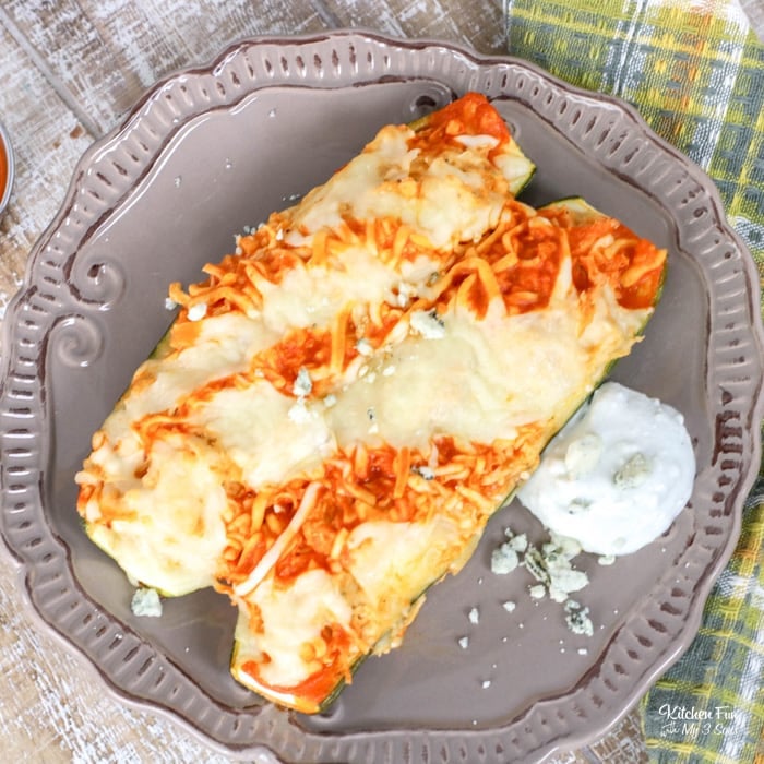 Overhead view of two buffalo chicken zucchini boats on a plate.