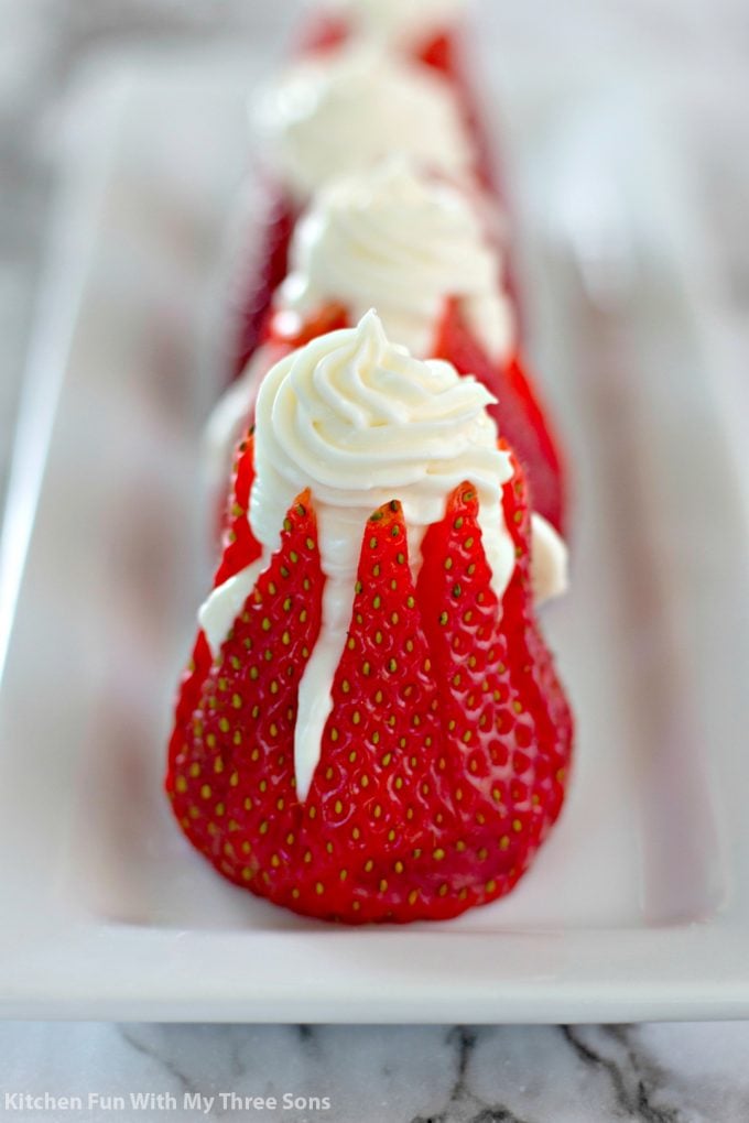 5 Ingredient Cheesecake Stuffed Strawberries lined up on a white platter