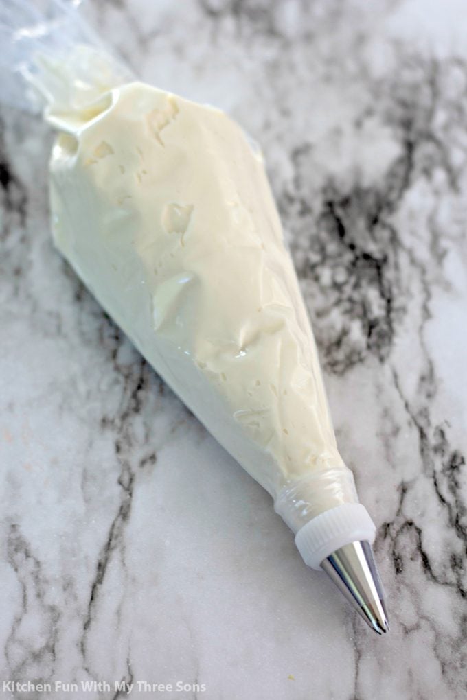 a piping bag filled with creamy cheesecake filling