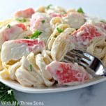 Plate of Crab Fettuccine Alfredo with fresh herbs.