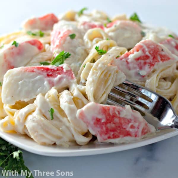 Plate of Crab Fettuccine Alfredo with fresh herbs.