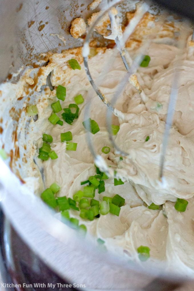 whipping together cream cheese, green onions, and seasonings