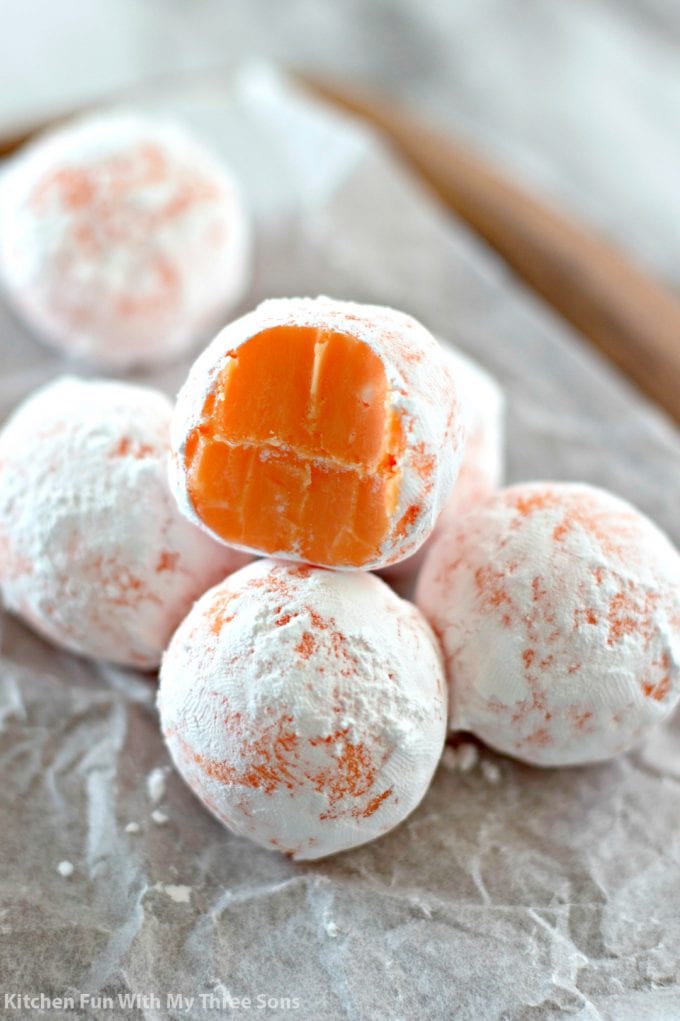 Easy Orange Creamsicle Truffles stacked on parchment paper