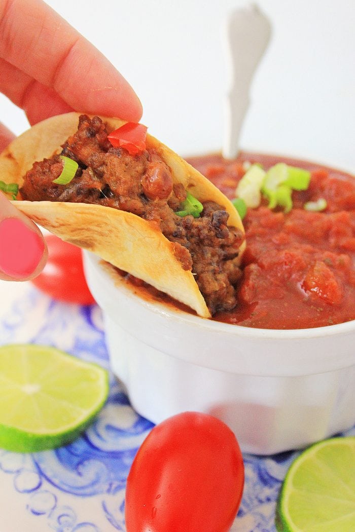dipping a mini taco into salsa