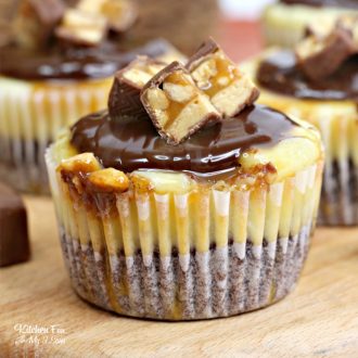 Close up of mini Snickers cheesecake bites on a wooden platter.