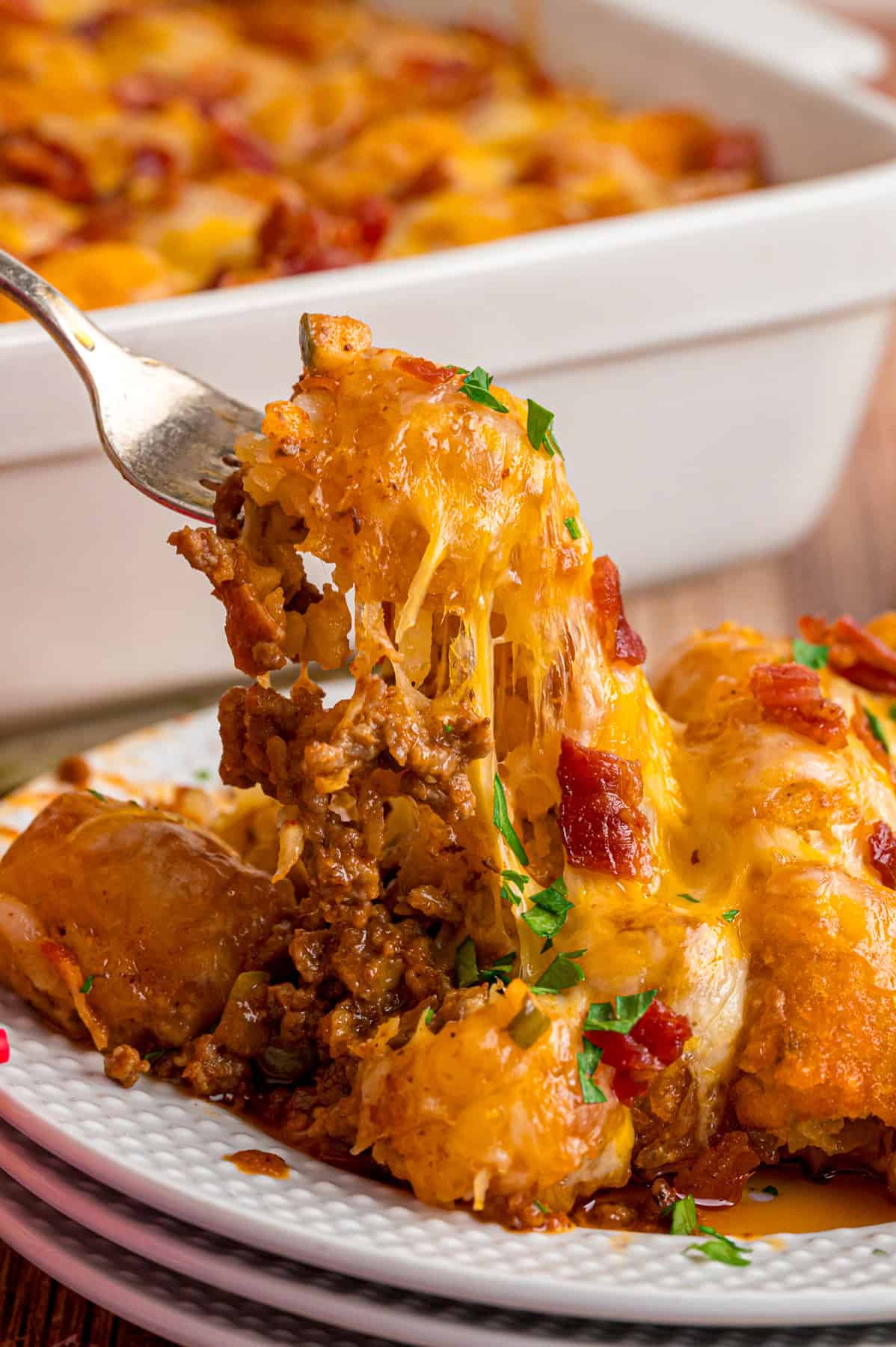 A bite of cheeseburger tater tot casserole on a fork