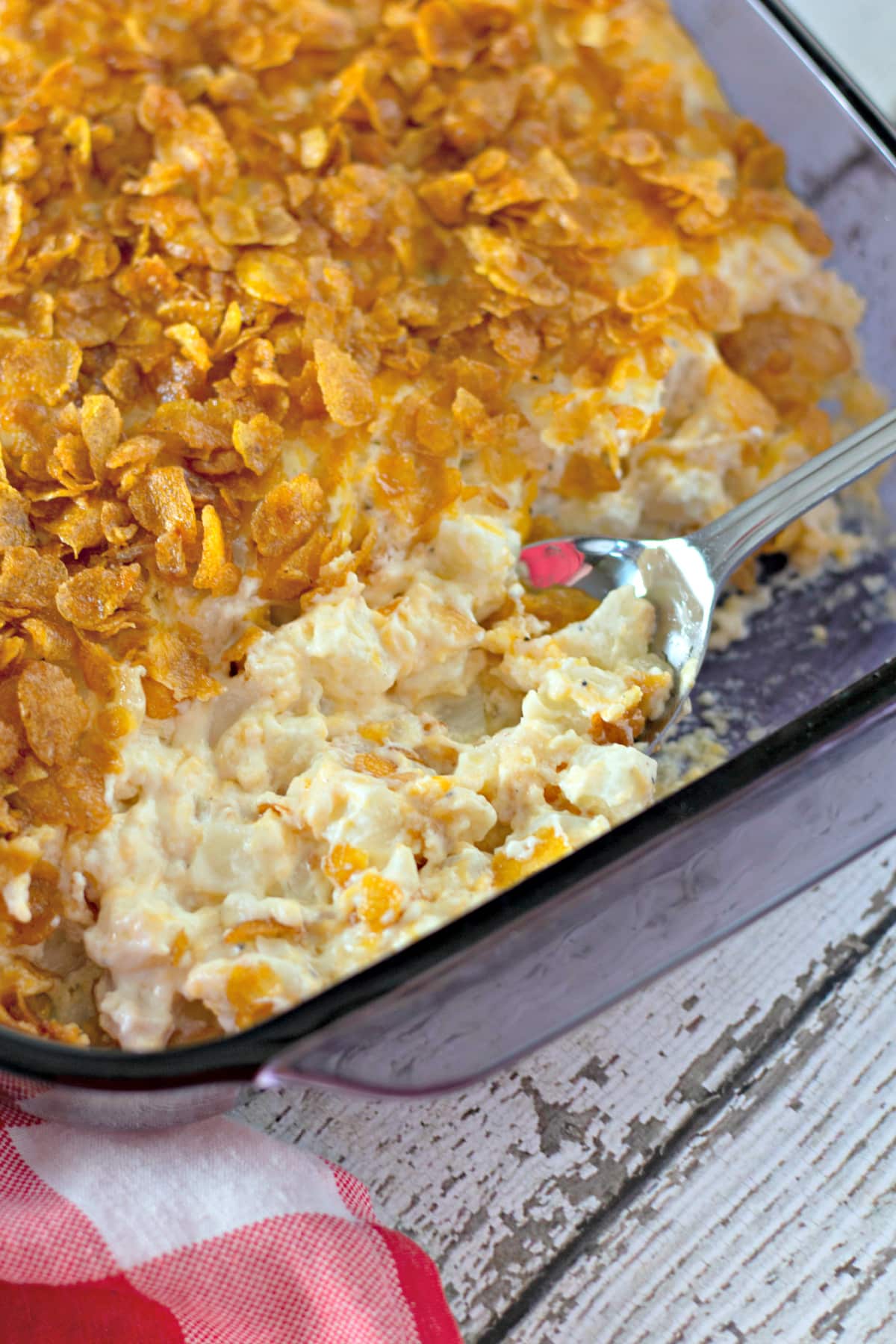 Baked Funeral Potatoes in a pan with a spoon
