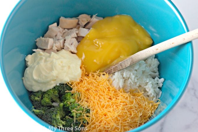 chicken, mayonnaise, cheese, rice, broccoli, and cream of chicken soup in a teal bowl