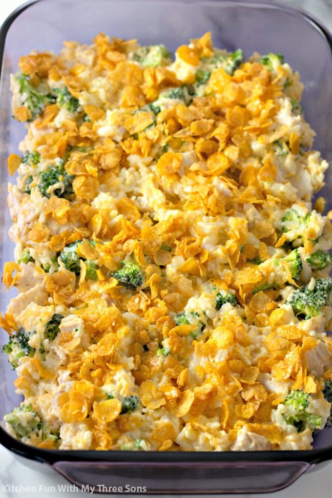 chicken and rice with cheese and broccoli in a glass baking dish topped with buttered Corn Flakes