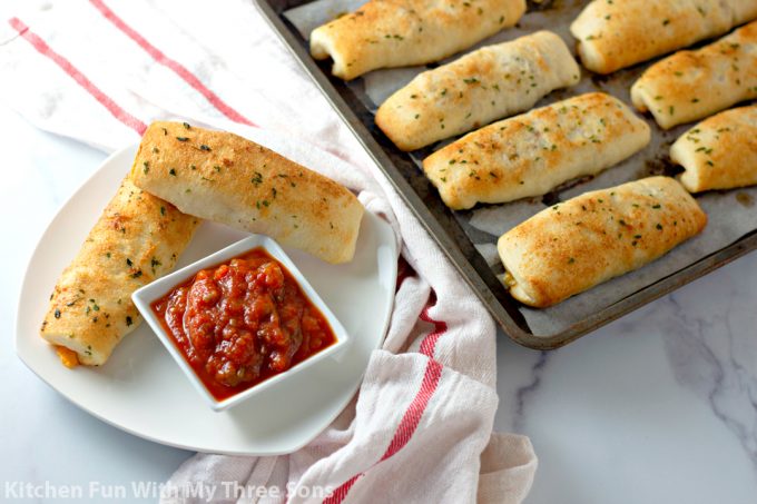 Cheesy Taco Breadsticks on a white plate with salsa