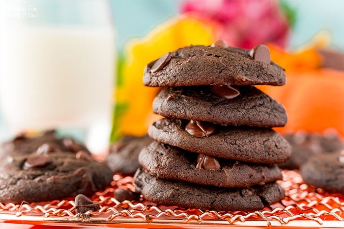 A stack of double chocolate pumpkin cookies on a wire rack.