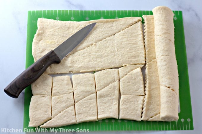 cutting crescent roll dough on a cutting mat