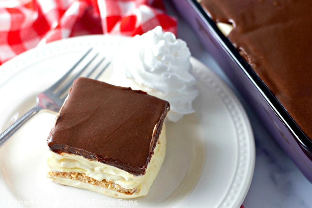No Bake Eclair Cake on a white plate with whipped cream