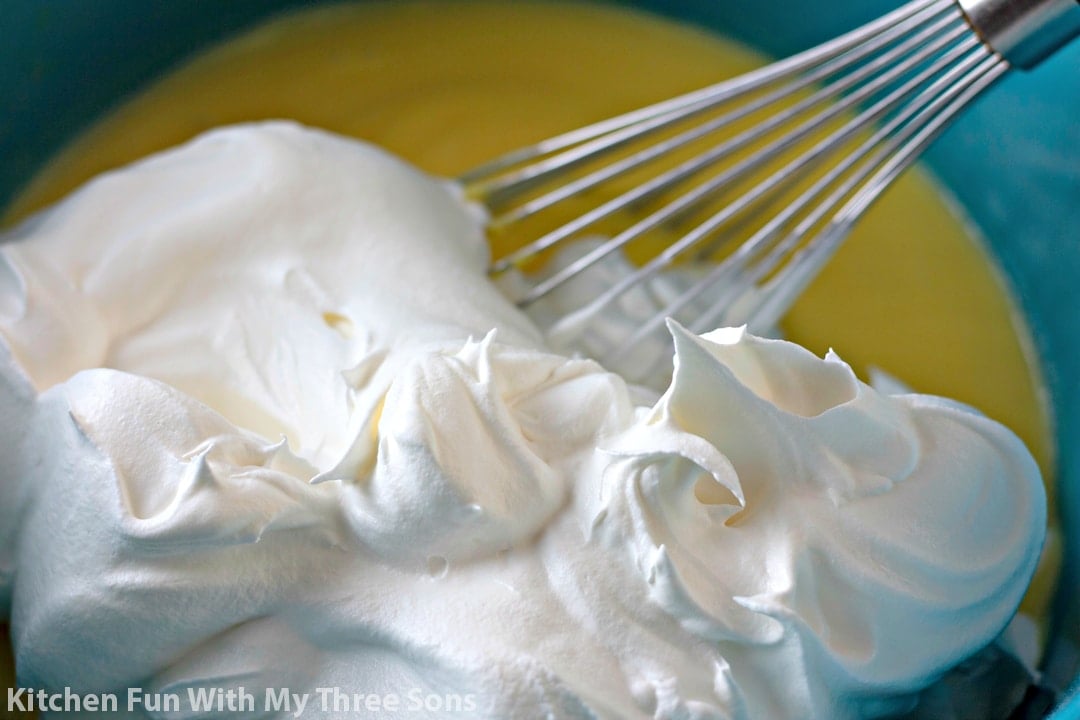 mixing vanilla pudding and Cool Whip together in a teal bowl