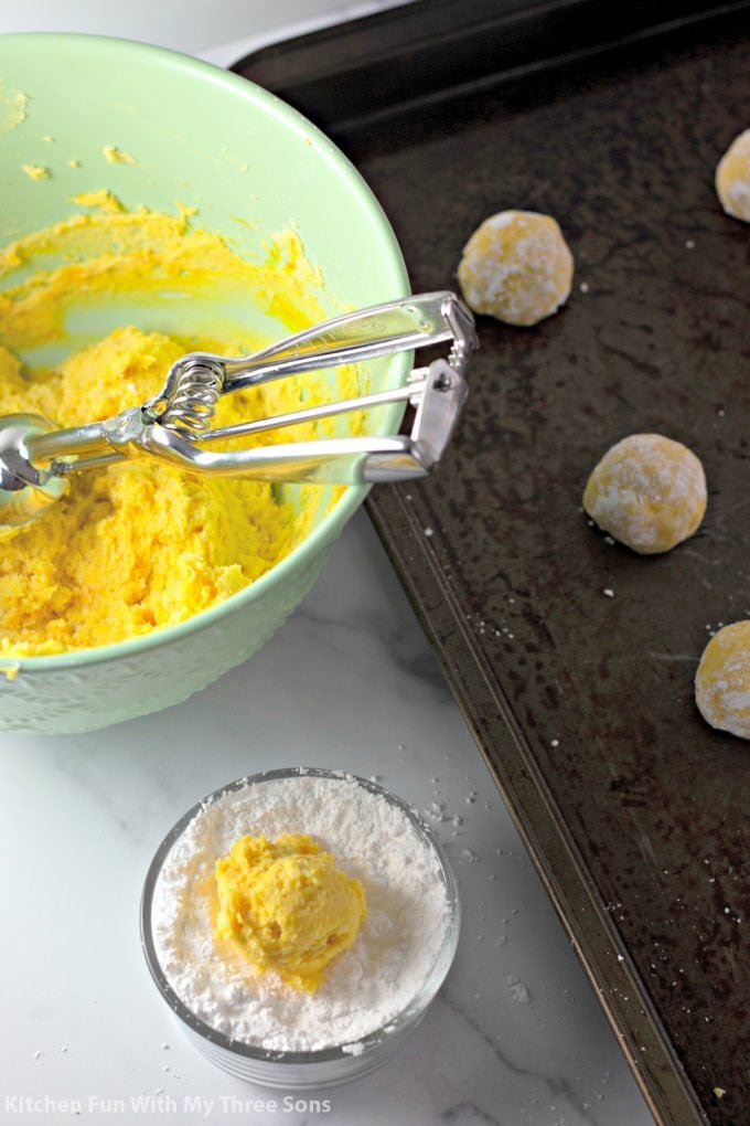 scooping lemon cookie dough onto cookie sheets