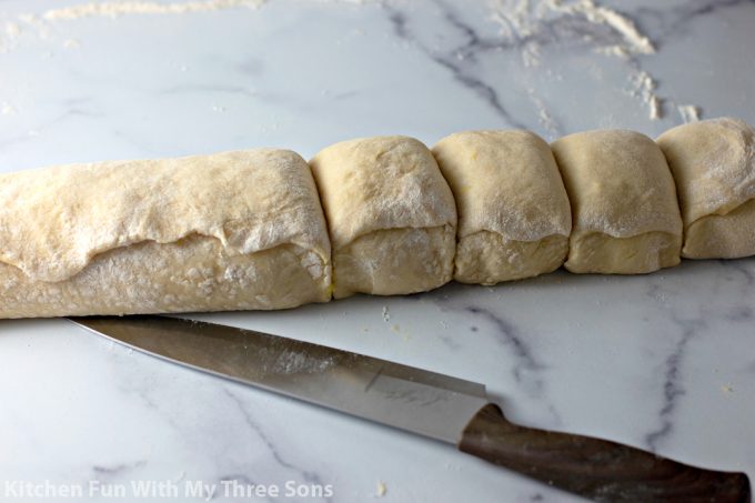 cutting a log of dough into rolls
