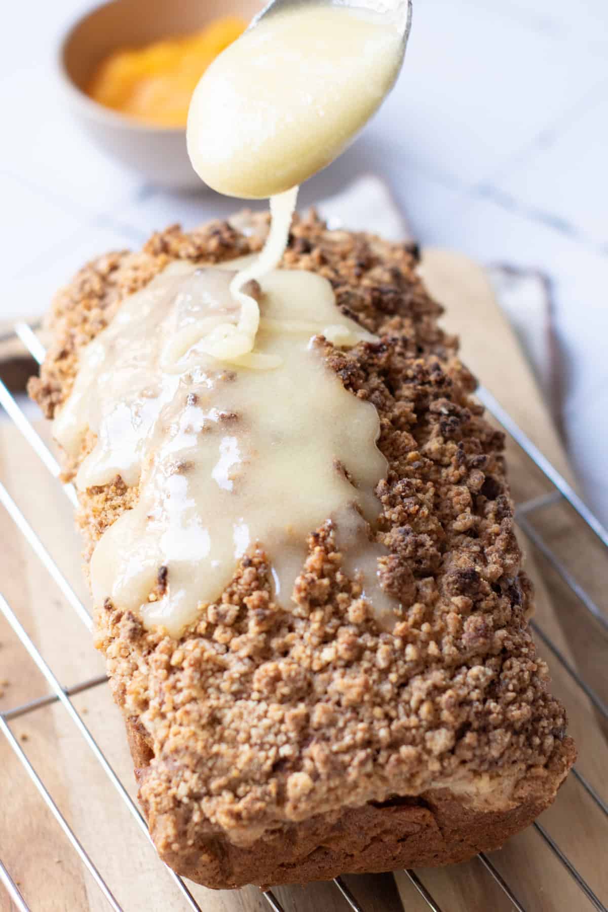 pouring glaze over Pumpkin Streusel Bread