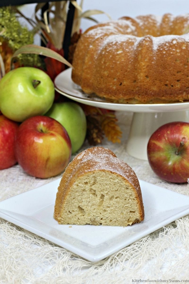 Apple Cider Doughnut Cake with apples in the background.