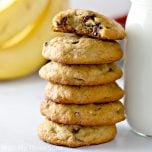 Banana Chocolate Chip Cookies stacked next to a glass of milk