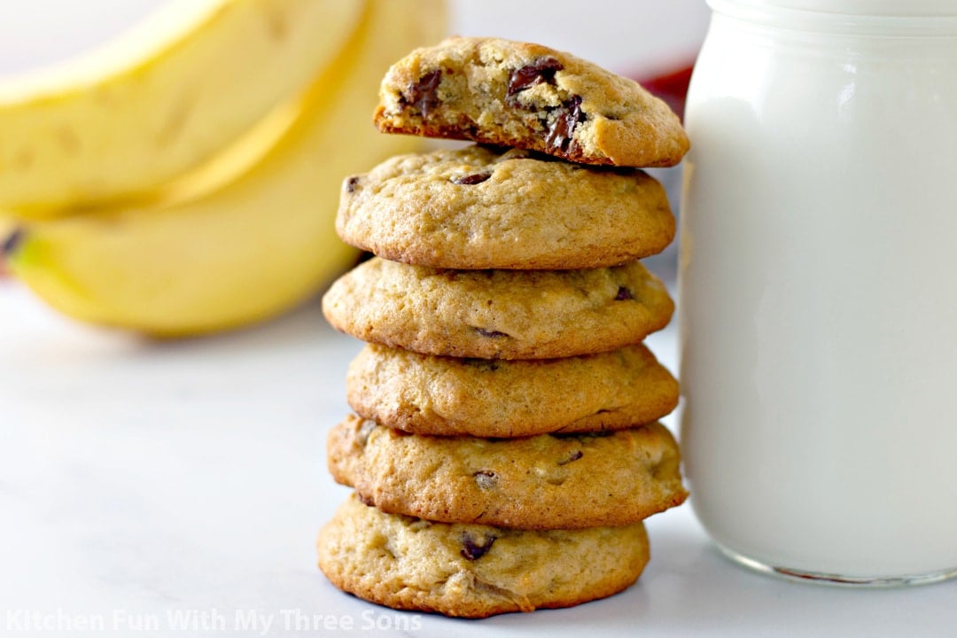 Banana Chocolate Chip Cookies stacked next to a glass of milk