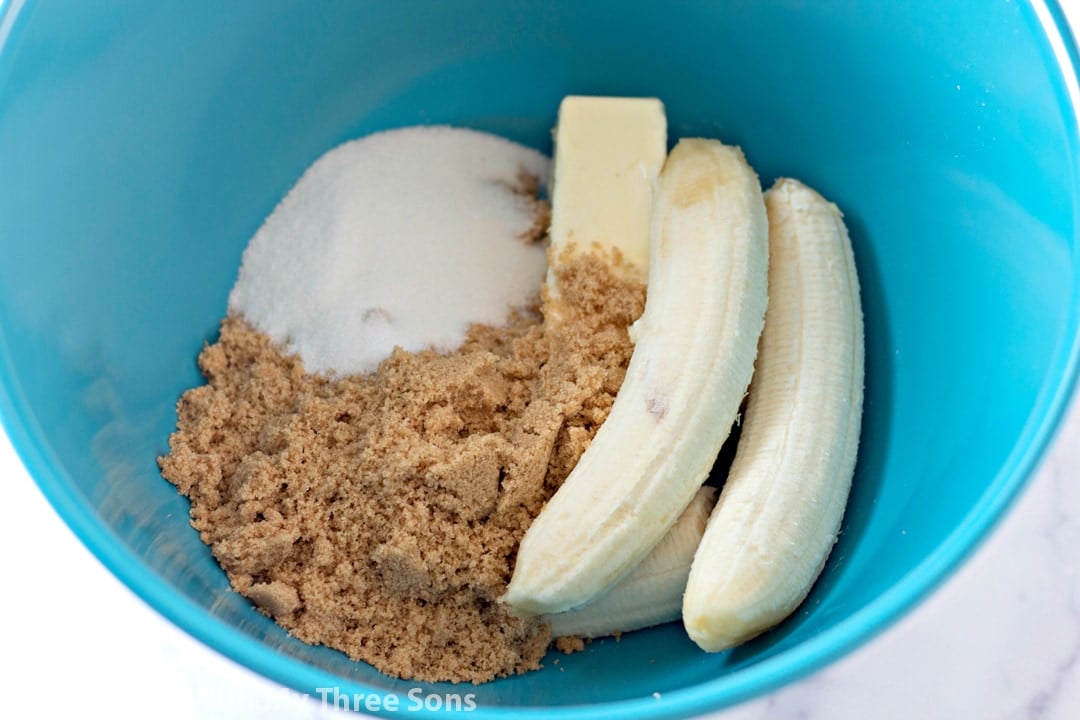 A banana, butter, and sugar in a mixing bowl