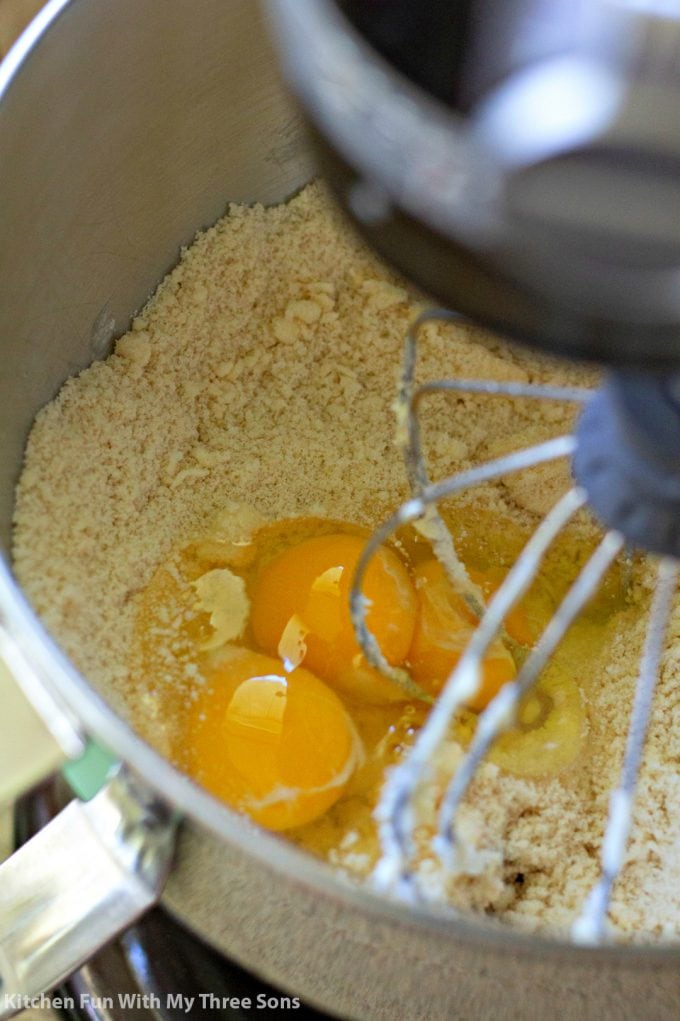 beating eggs into the cake batter with an electric mixer