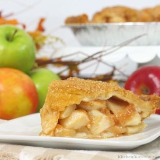 A close-up of Bourbon Apple Pie with a flaky sugar-studded crust and chunks of apple in a gooey filling.