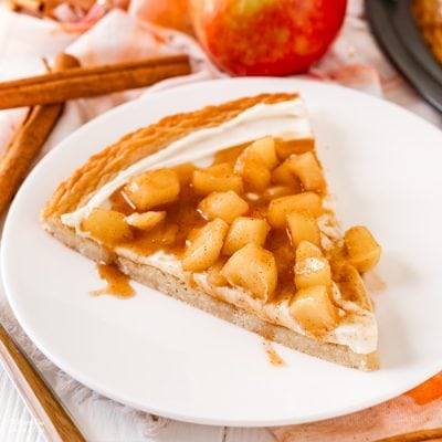 Caramel Apple Fruit Pizza is a great fall dessert recipe - a sugar cookie with cream cheese frosting and a cinnamon caramel apple topping. 