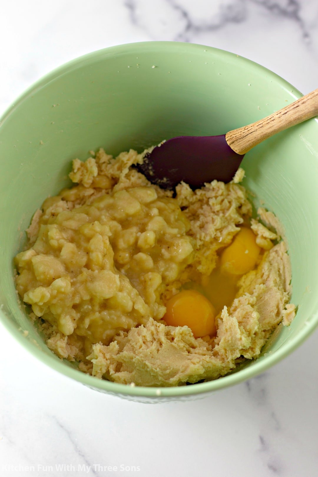 Creamed butter and sugar and eggs in a green mixing bowl