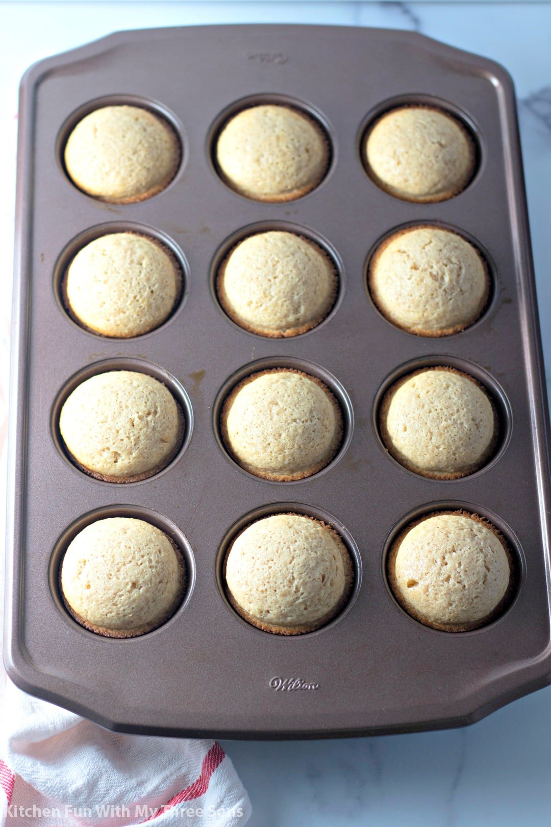 A twelve-count cupcake tin filled with freshly-baked donut muffins