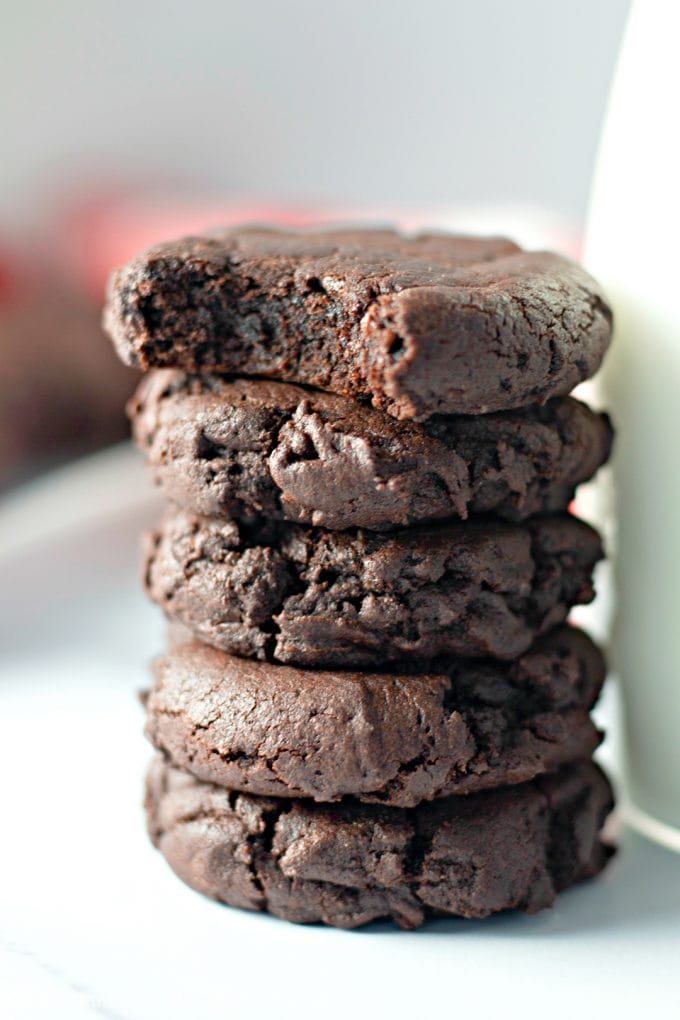 stacked Dark Chocolate Cookies next to milk