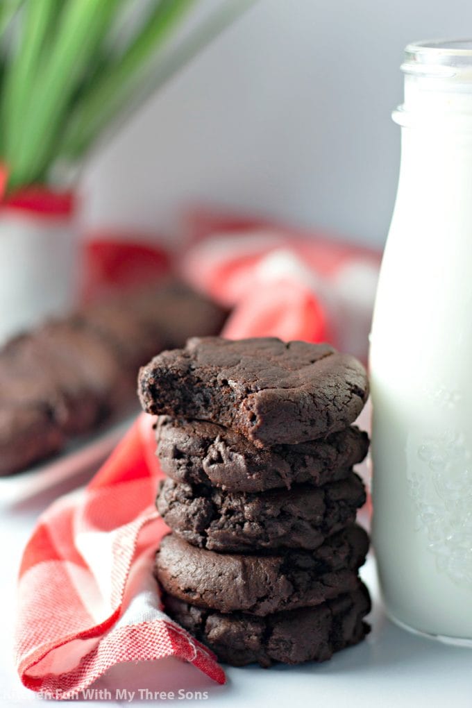 Dark Chocolate Cookies stacked next to a bottle of milk