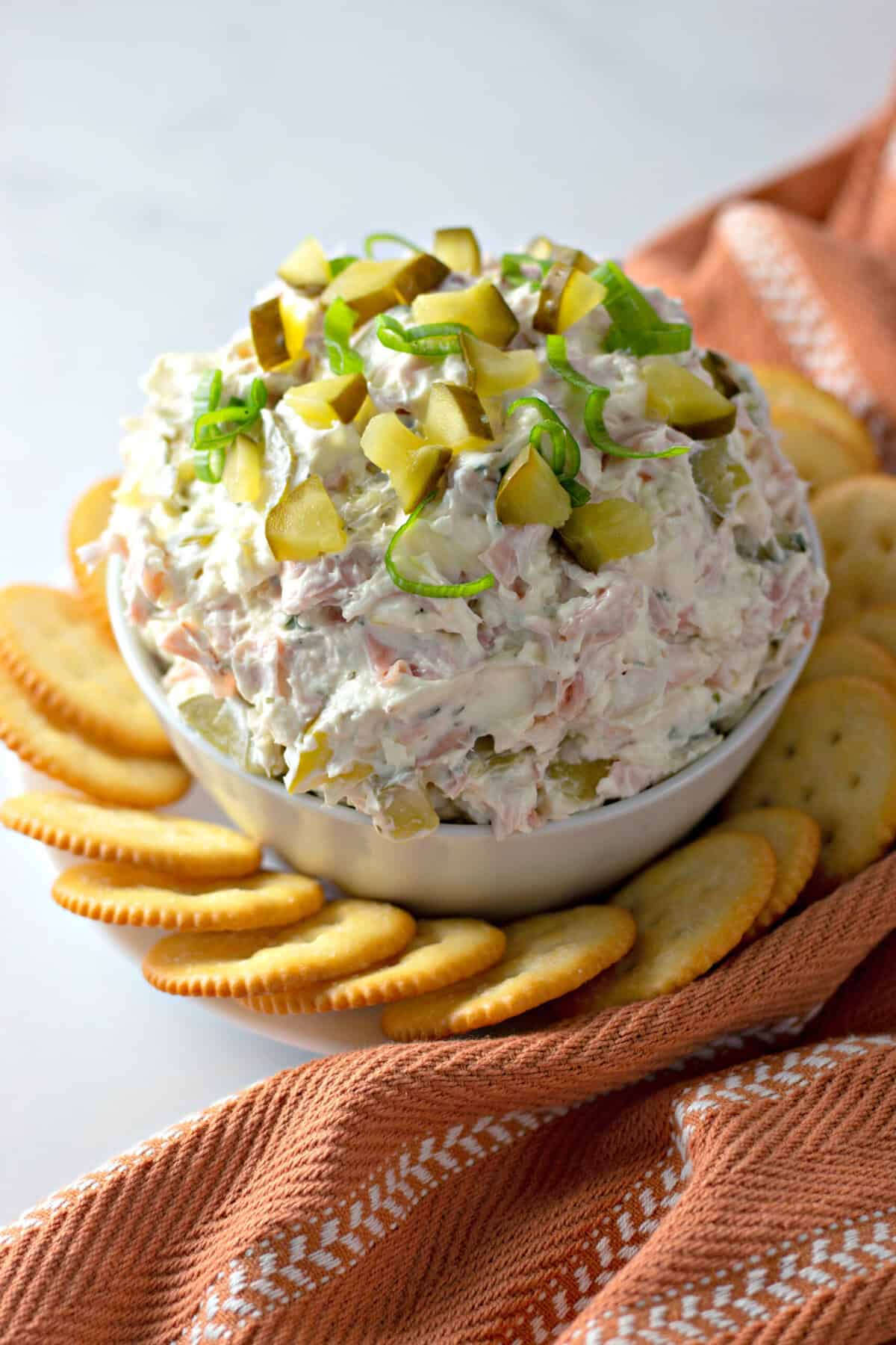 Overhead view of a bowl of pickle dip surrounded by crackers