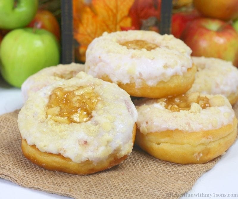 Easy Apple Donuts Recipe with framed leaves and apples behind it.