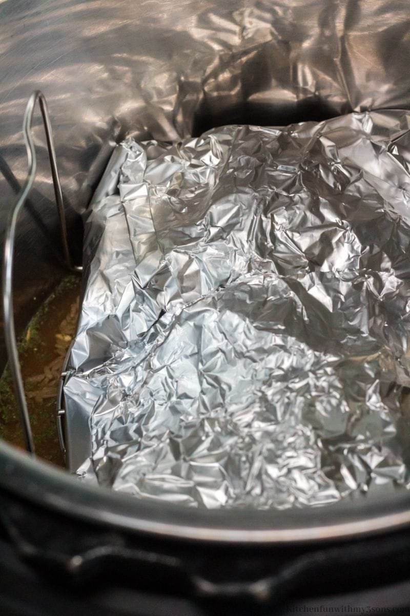 The salmon wrapped in foil and placed on top of the trivet in the Instant Pot.