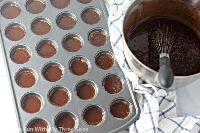 pouring cake batter into the mini muffin pan