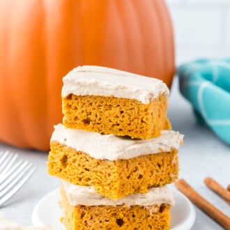 A stack of 3 pumpkin bars with cream cheese frosting
