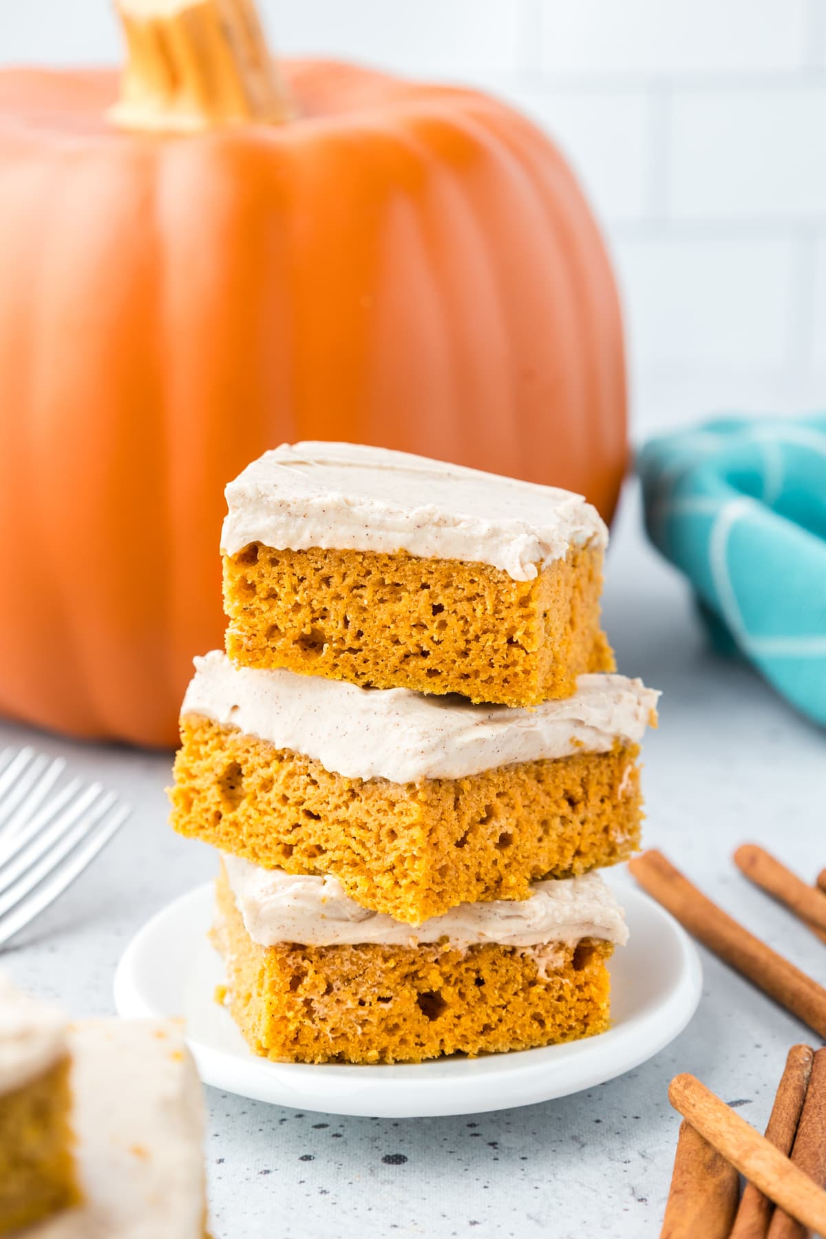 A stack of 3 pumpkin bars with cream cheese frosting