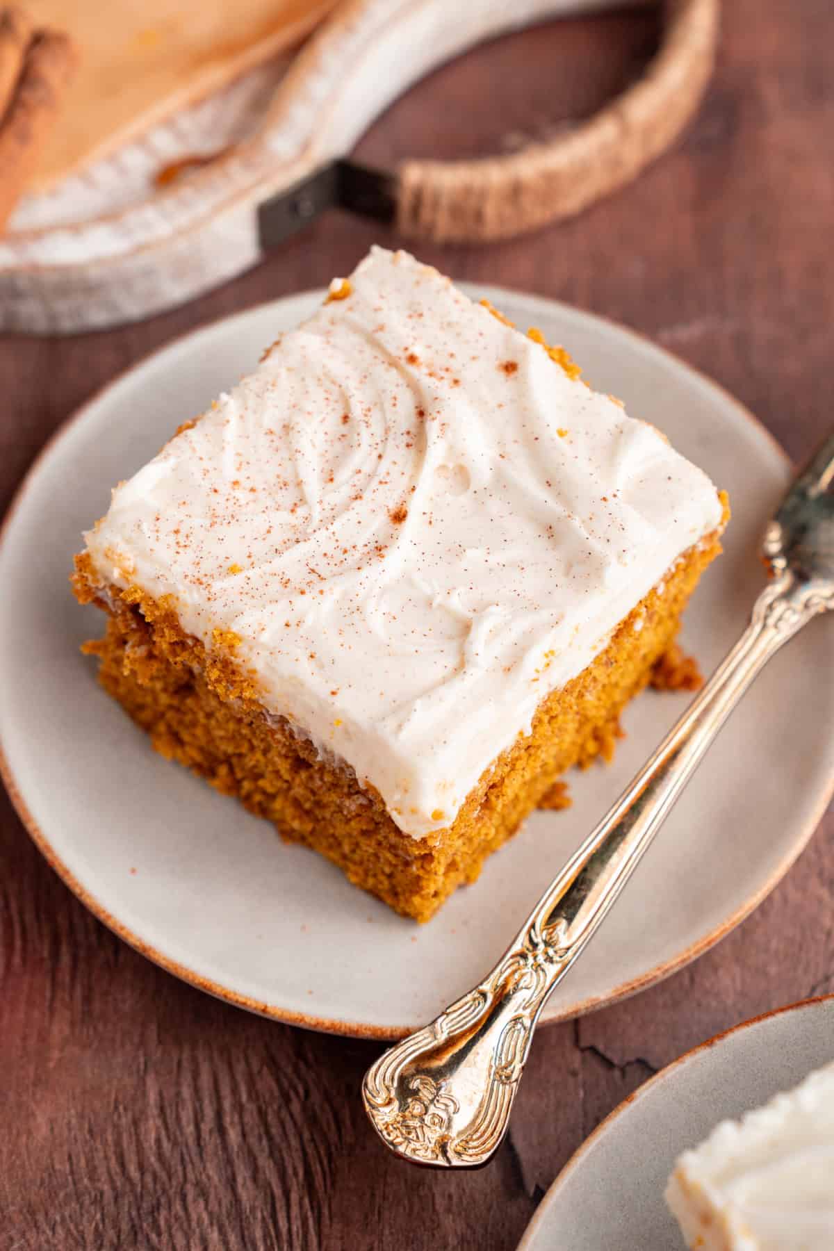 These Pumpkin Bars are soft, incredibly moist and loaded with warm spices. top view of a pumpkin bar with cream cheese frosting on a plate