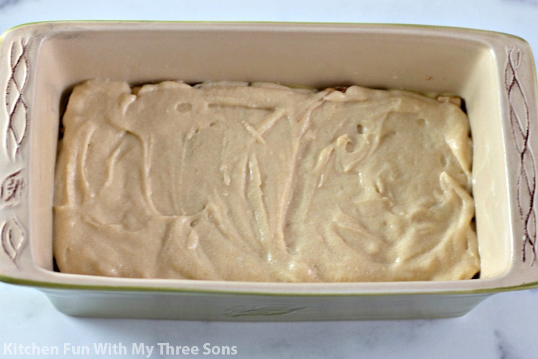 spreading batter over apples in the loaf pan