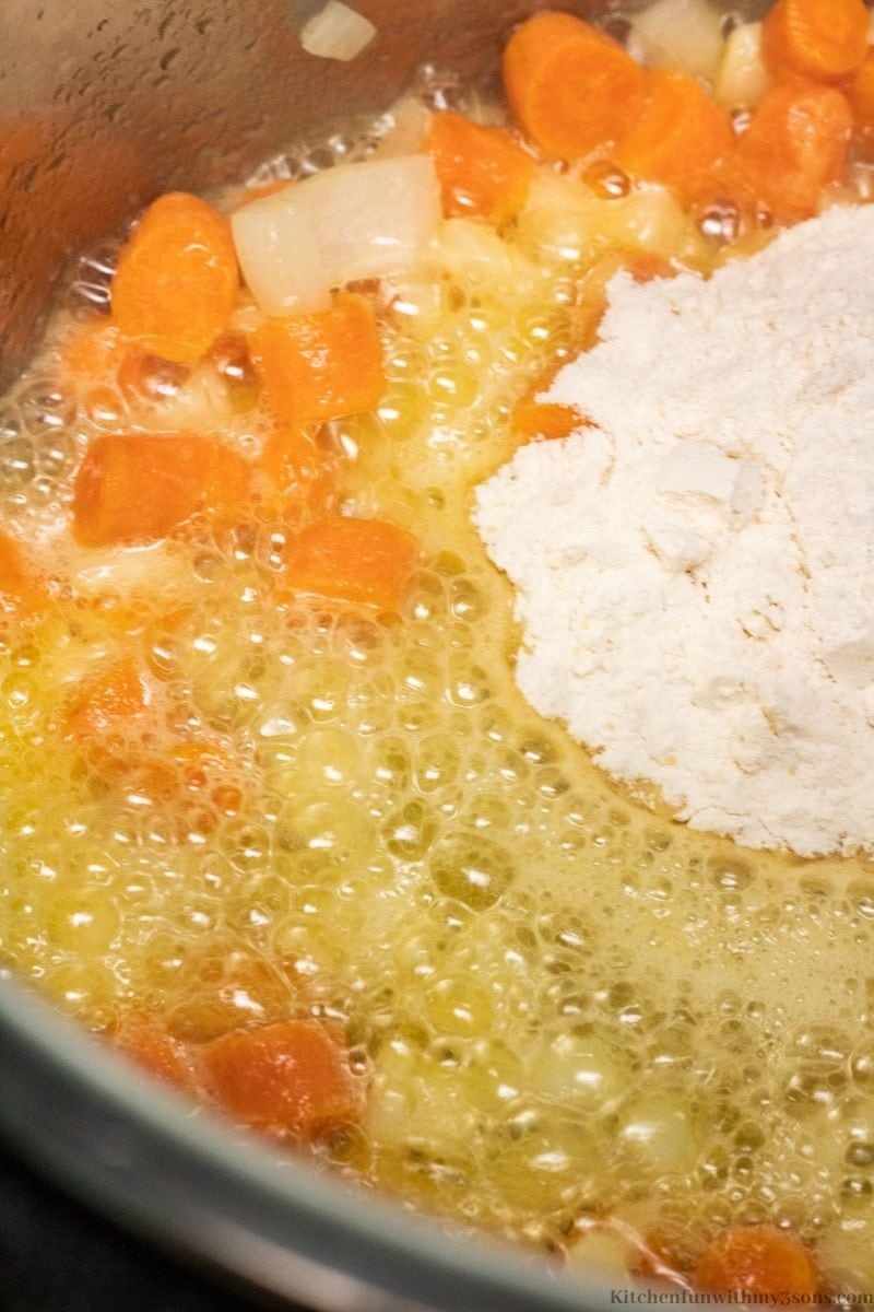The flour being added into the vegetables and broth.