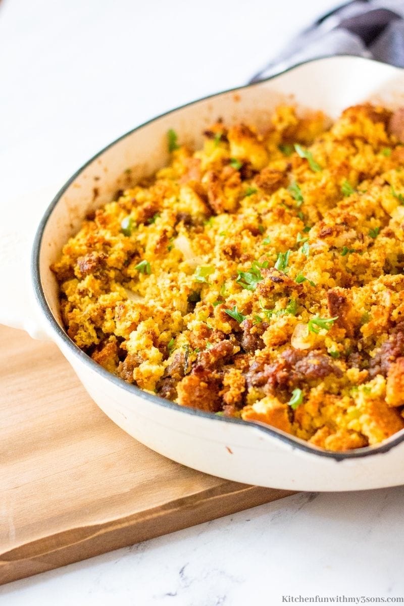Best Ever Sausage Cornbread Stuffing finished and in a white skillet.