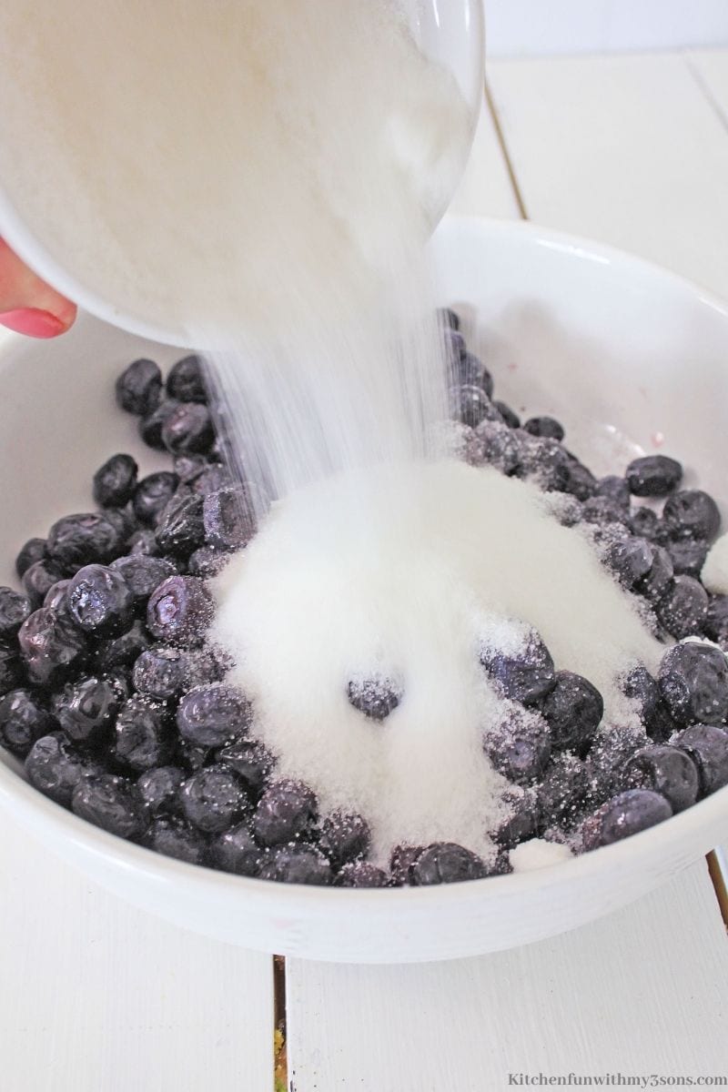 Mixing together the blueberries and sugar.