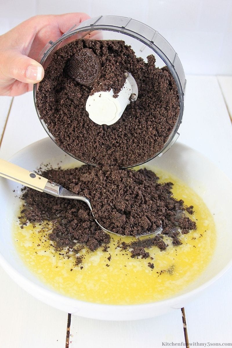 Mixing the Oreos and butter to form the crust.
