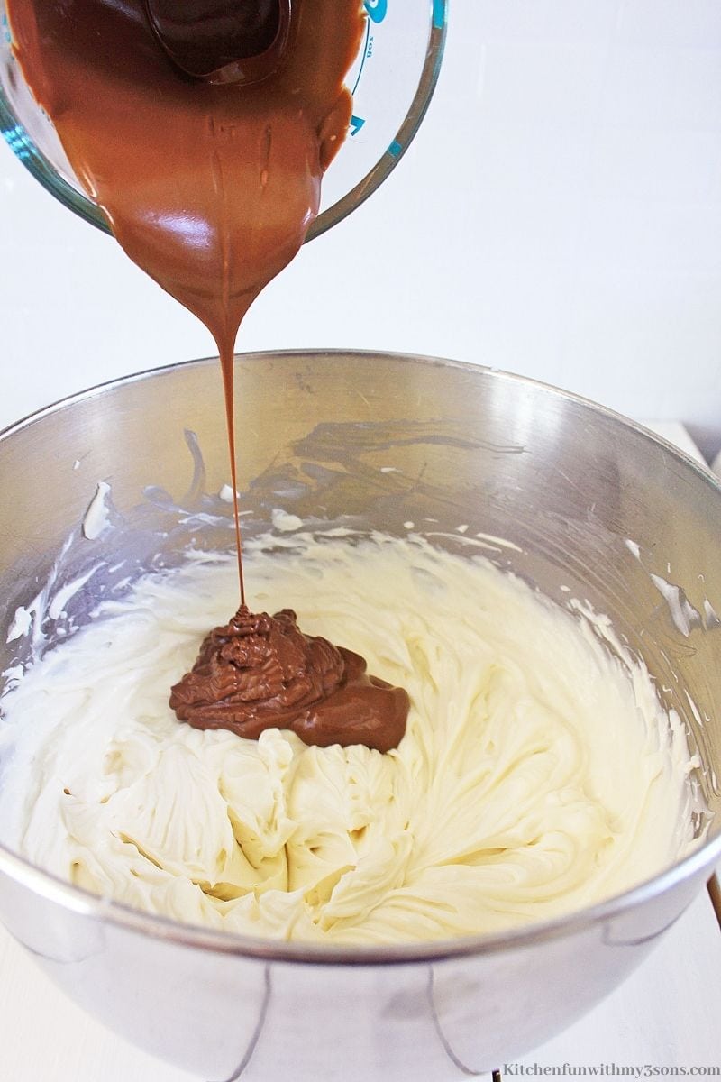 Adding the melted chocolate to the cheesecake mixture.