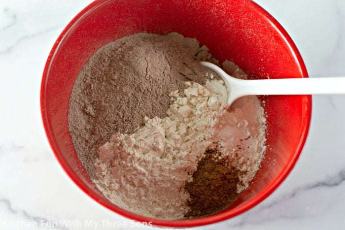 stirring together the dry ingredients in a red bowl with a white spoon