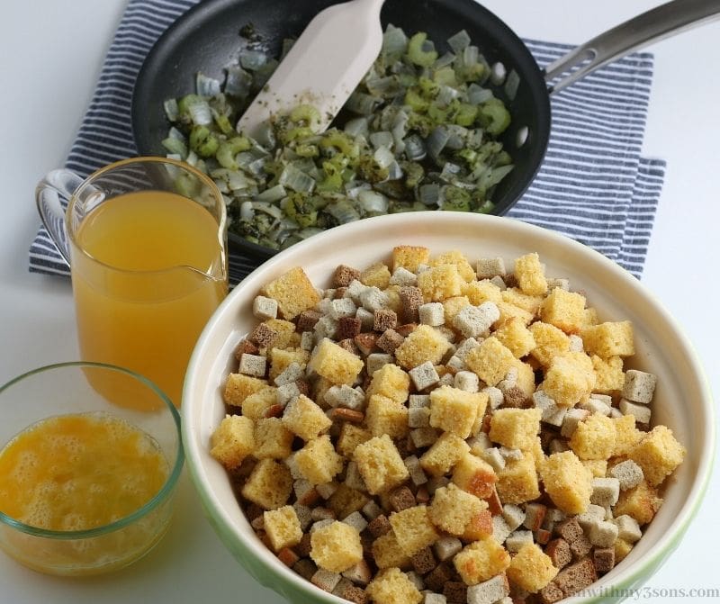 A bowl of cornbread and stuffing cubes in front of sauteed celery 