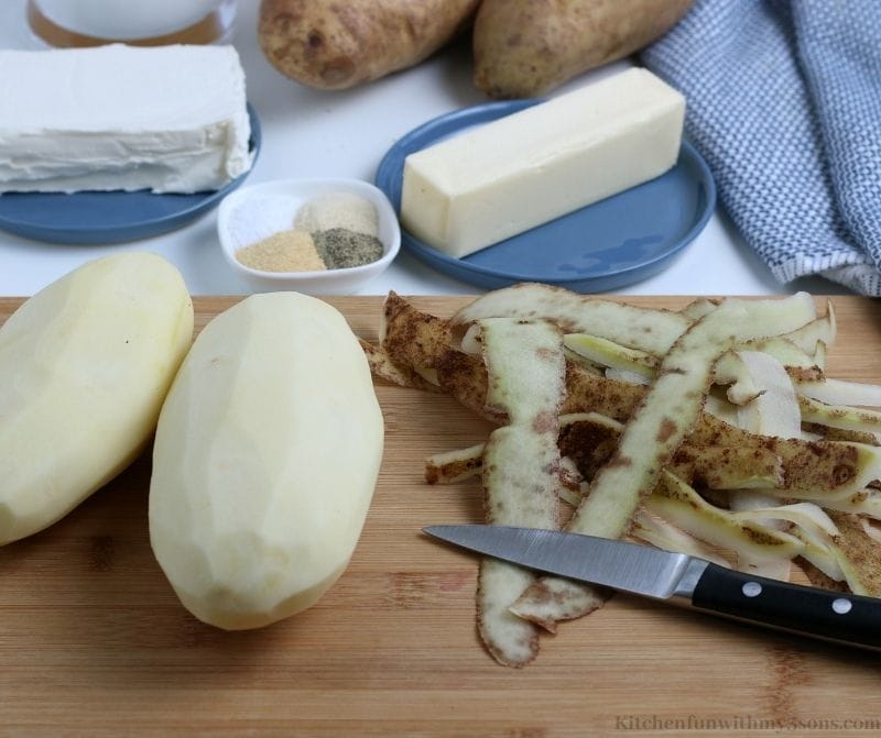 Your potatoes peeled on a cutting board.