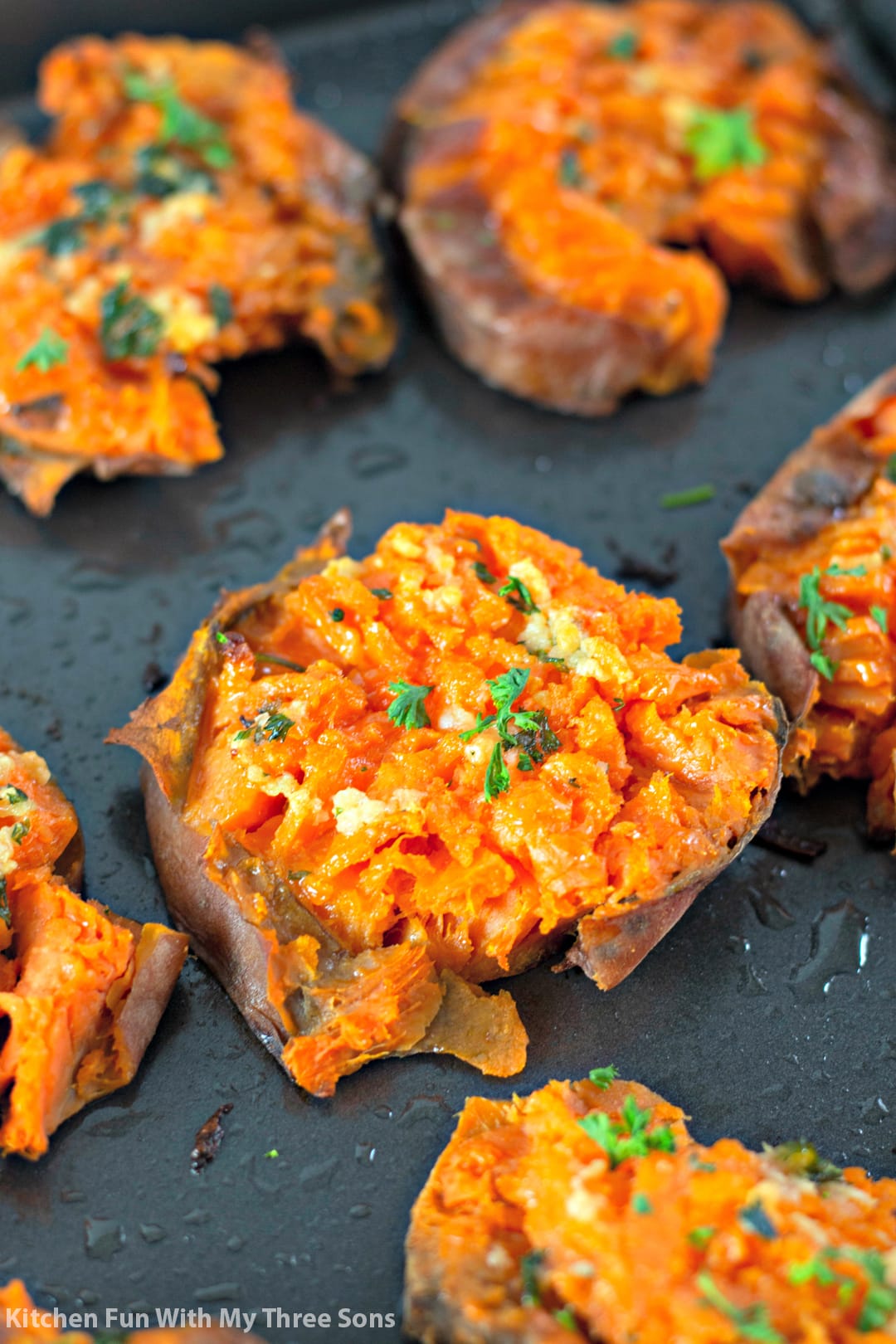 freshly baked Garlic Butter Smashed Sweet Potatoes on a cookie sheet